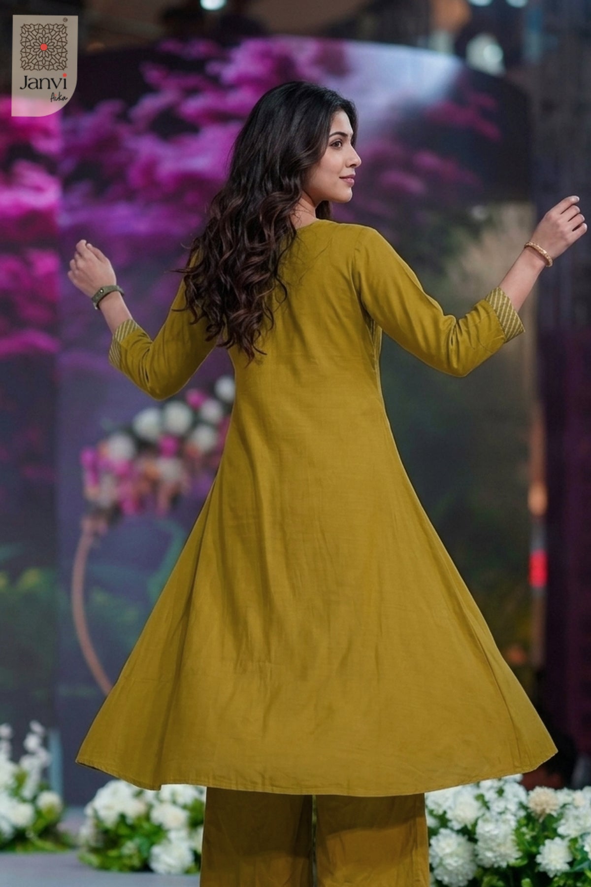 Rear view turning over shoulder in an embroidered moss green indo western party wear for ladies.