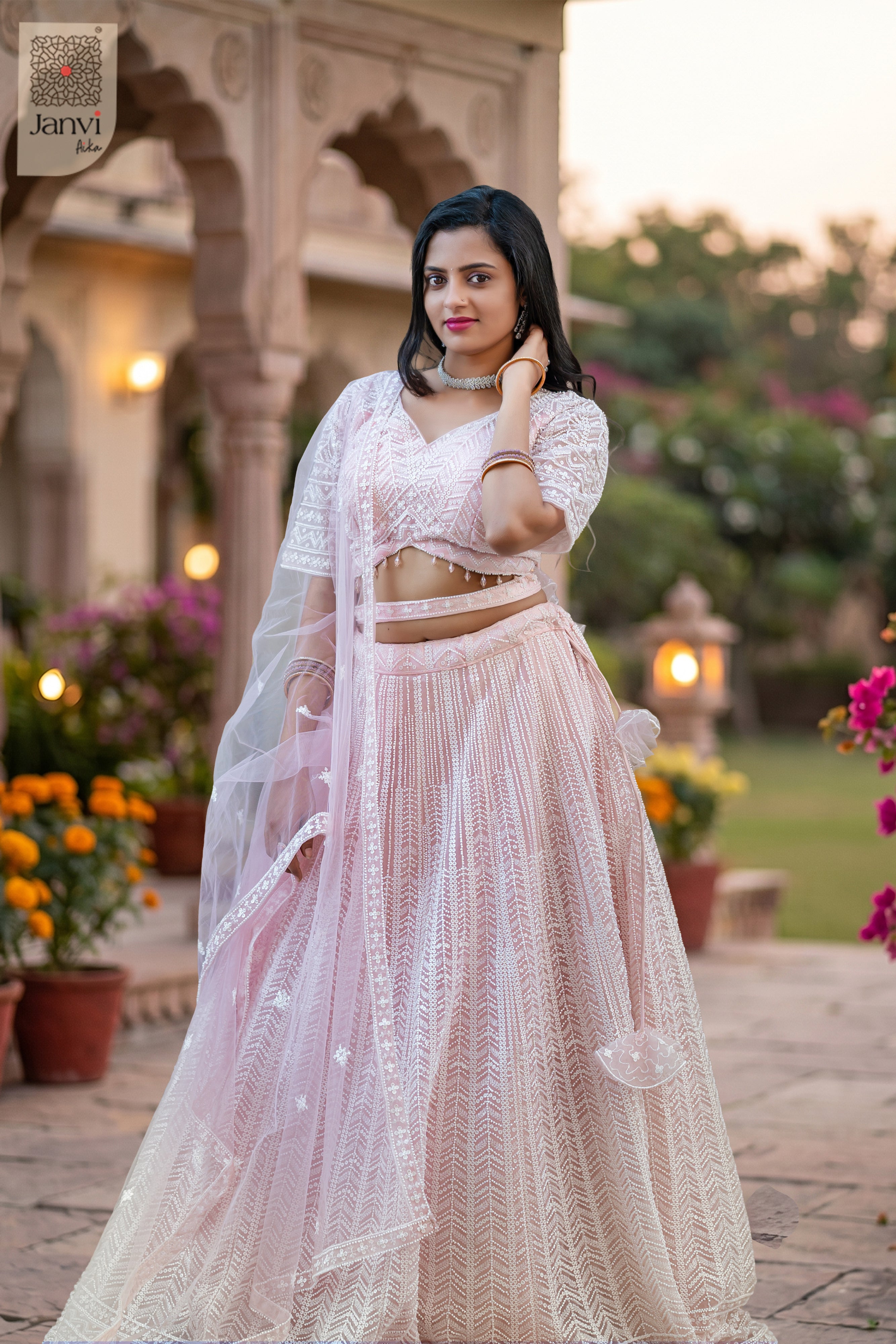 This front full standing shot showcases a gorgeous pink net pink lehenga saree for weddings.