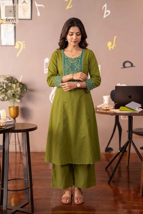 Front standing pose with clasped hands in olive green tailored indo western party wear for ladies.