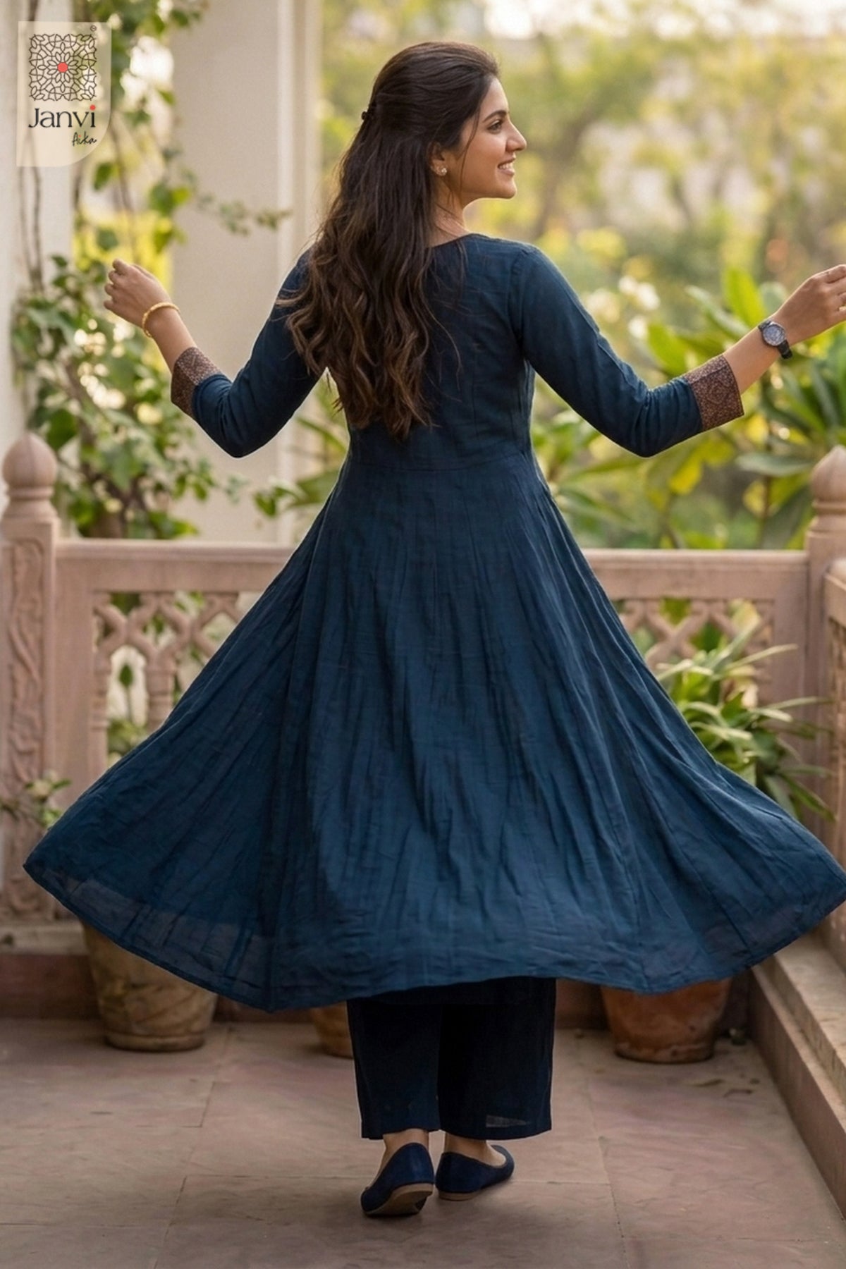 Dynamic twirling motion showing the navy blue flare of a georgette anarkali dress.