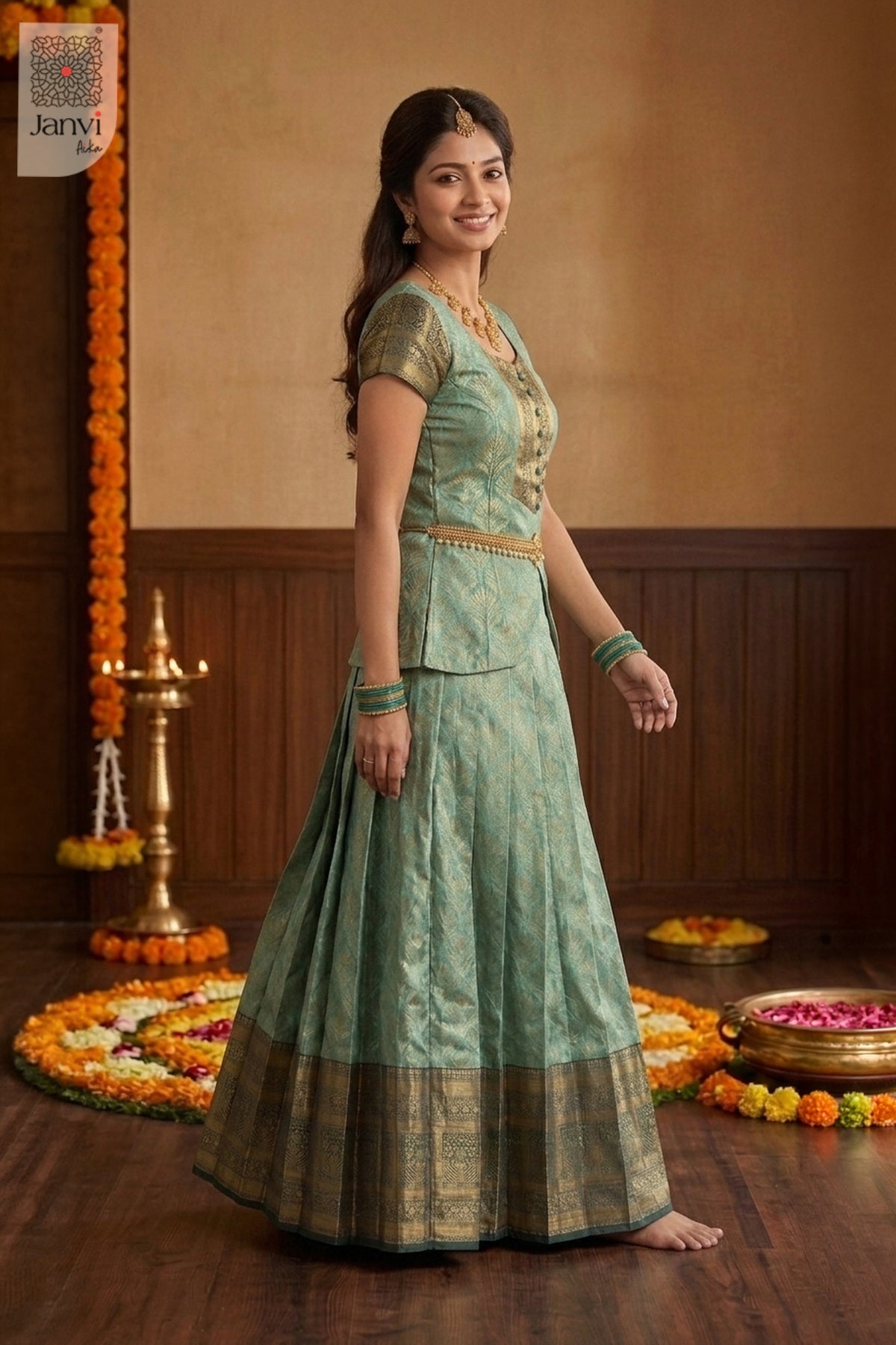 Graceful studio shot of a jade green blouse and lehenga with wide gold borders.