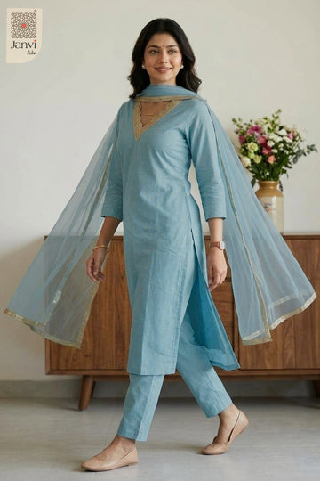 Standing pose holding printed floral dupatta wide in an embroidered chudidar set.