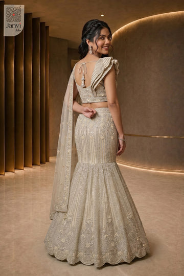 Charming lehenga with blouse showing a lovely rear full standing shot in a half white net style.