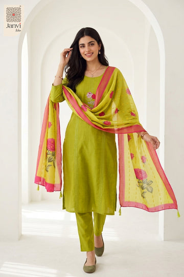 Front standing pose smiling in a yellowish green floral party wear churidar suit.