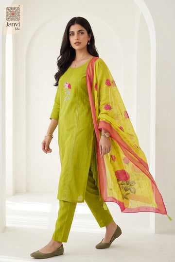 Three quarter walking pose showcasing pink embroidery on yellowish green chudidar set.