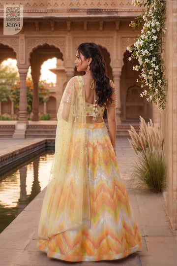 Rear full standing shot of a classic yellow/orange organza lehenga saree yellow design.