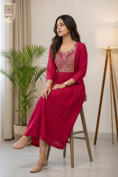 Seated pose beside indoor potted plant in strong pink long tunic tops for women flare