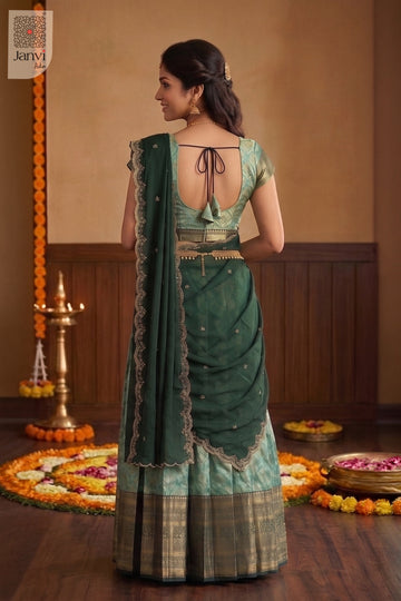 Rear view of south indian lehenga saree in jade green with wide woven borders.