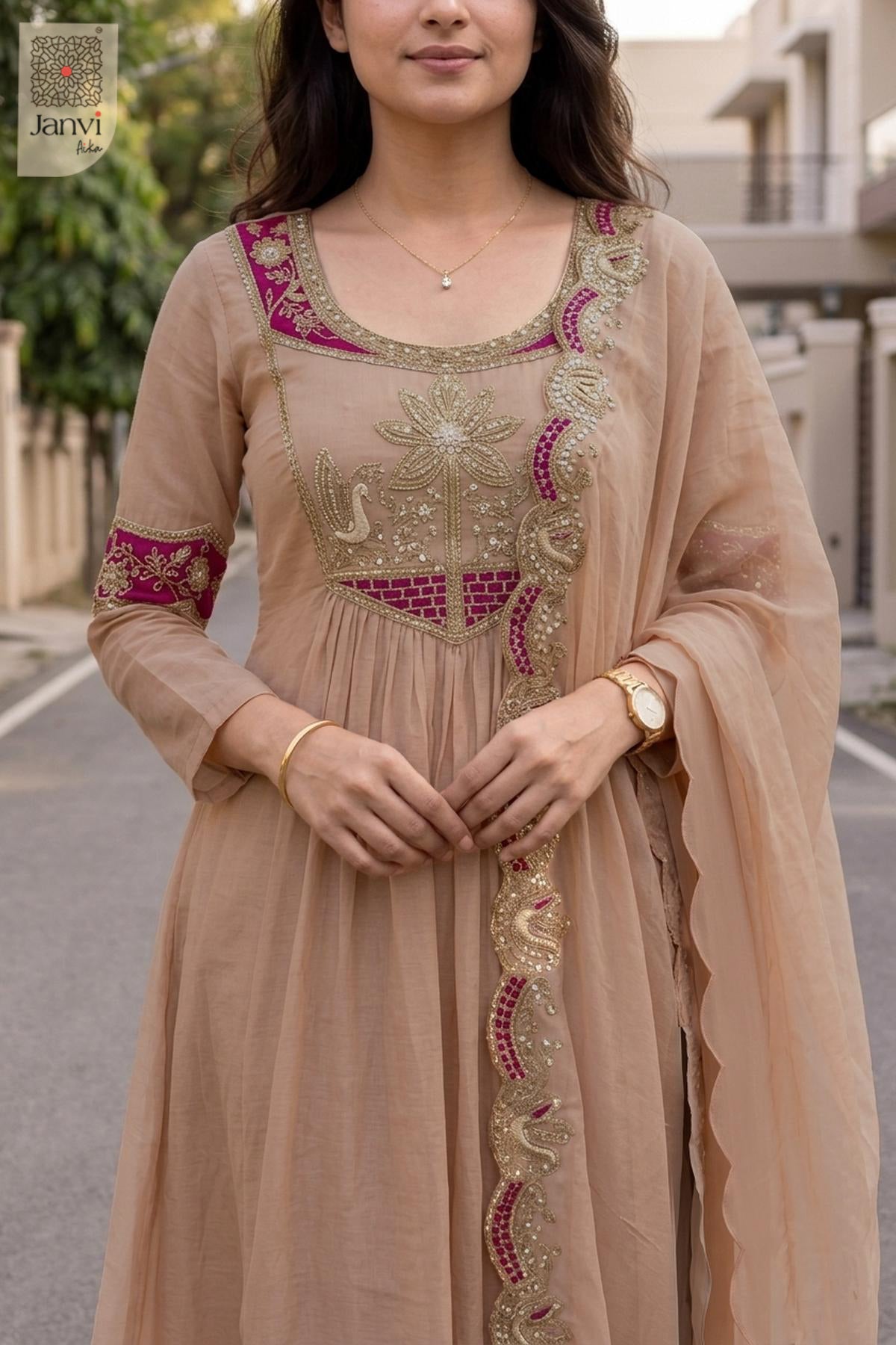 Close up view of intricate magenta zardozi work on a light peach short anarkali kurti.
