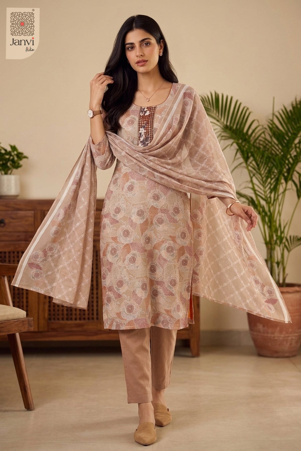 Standing indoor pose spreading out light peach red drape in a festive chudidar set.