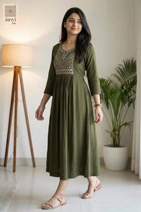 Front view of desaturated green long tunic tops for women standing in studio setting
