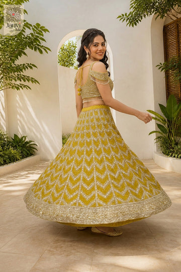 Rear full standing shot of a classic mustard gold georgette and net lehenga skirt with blouse design.