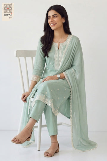 Elegant seated studio pose on a chair wearing a printed festive pastel chudidar set.