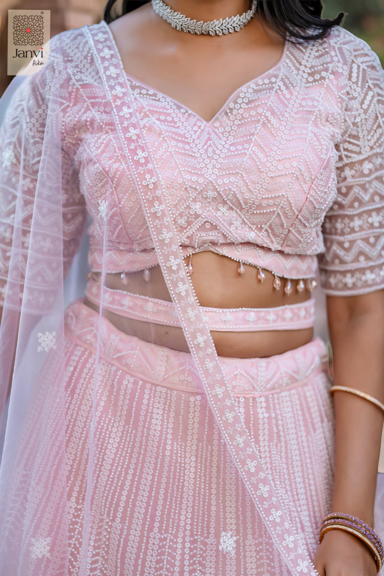 Stunning pink net lehenga for women traditional with an exquisite front neck close up.