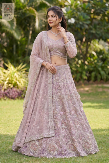 This front full standing shot showcases a gorgeous rose gold/dusty lilac net rose colour lehenga.