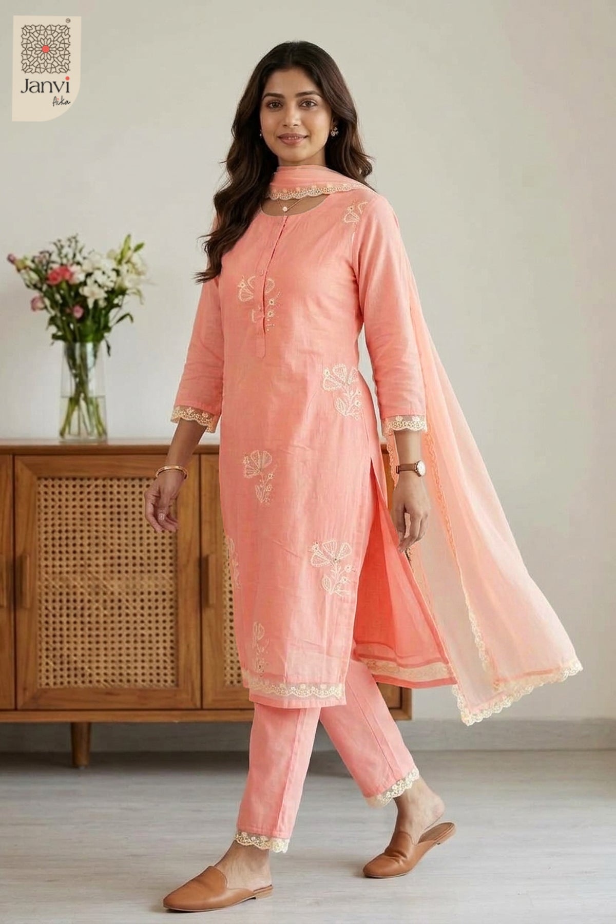 Mid length front standing view displaying fine threadwork on a peach chudidar set.