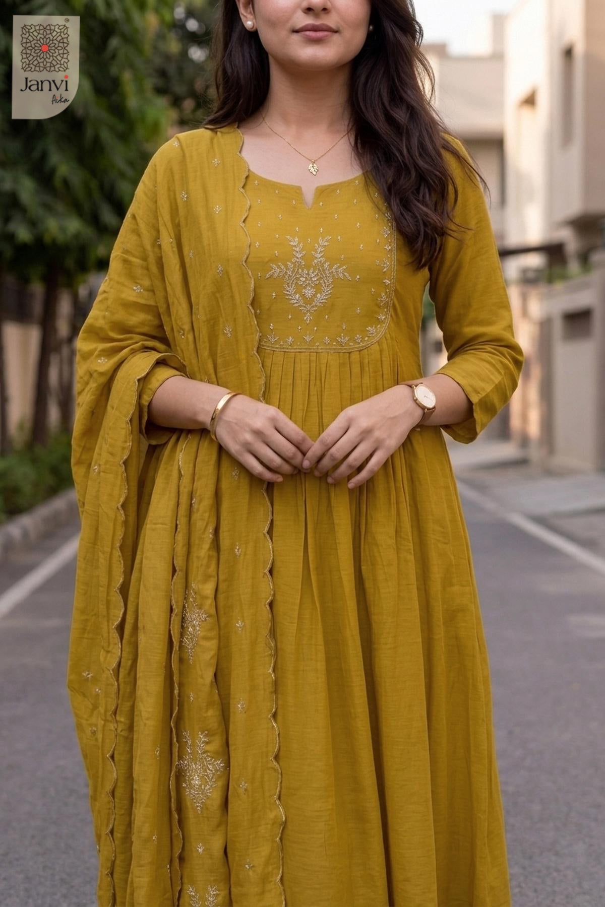 Close up portrait of gold thread embroidery on a mustard yellow anarkali kurti yoke.