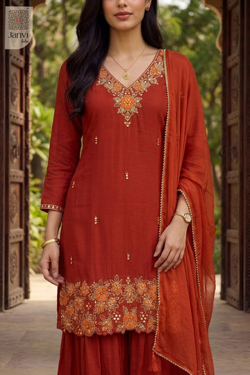 Close up view of floral hemline embroidery on an orange short anarkali kurti set.
