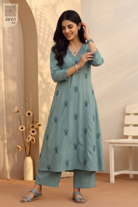 Mid length studio pose adjusting wrist watch wearing printed indo western party wear for ladies.