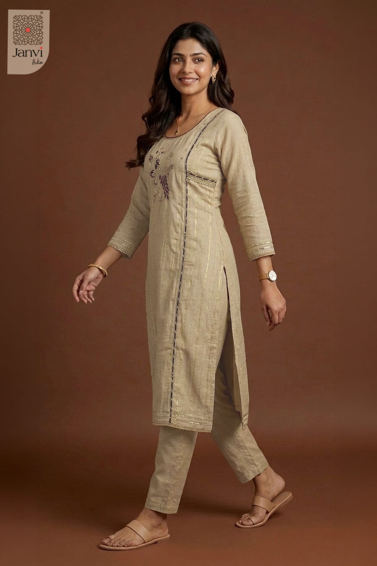 Mid length walking shot smiling warmly in grayish orange party wear churidar set.