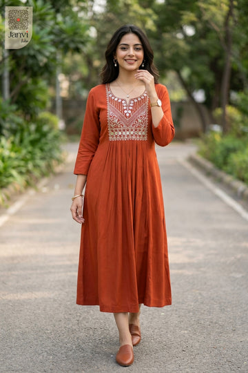 Model walking on paved garden pathway wearing rust party wear tops for women flared