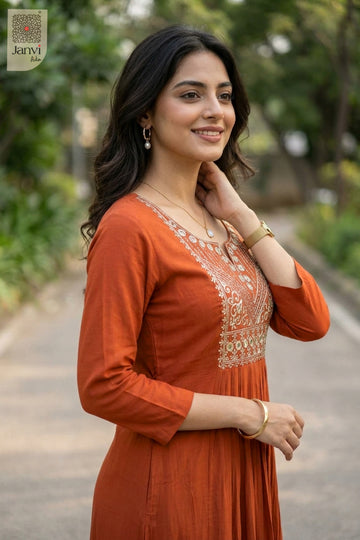 Side portrait of smiling woman touching neck in rust fancy tops for women outdoor pose