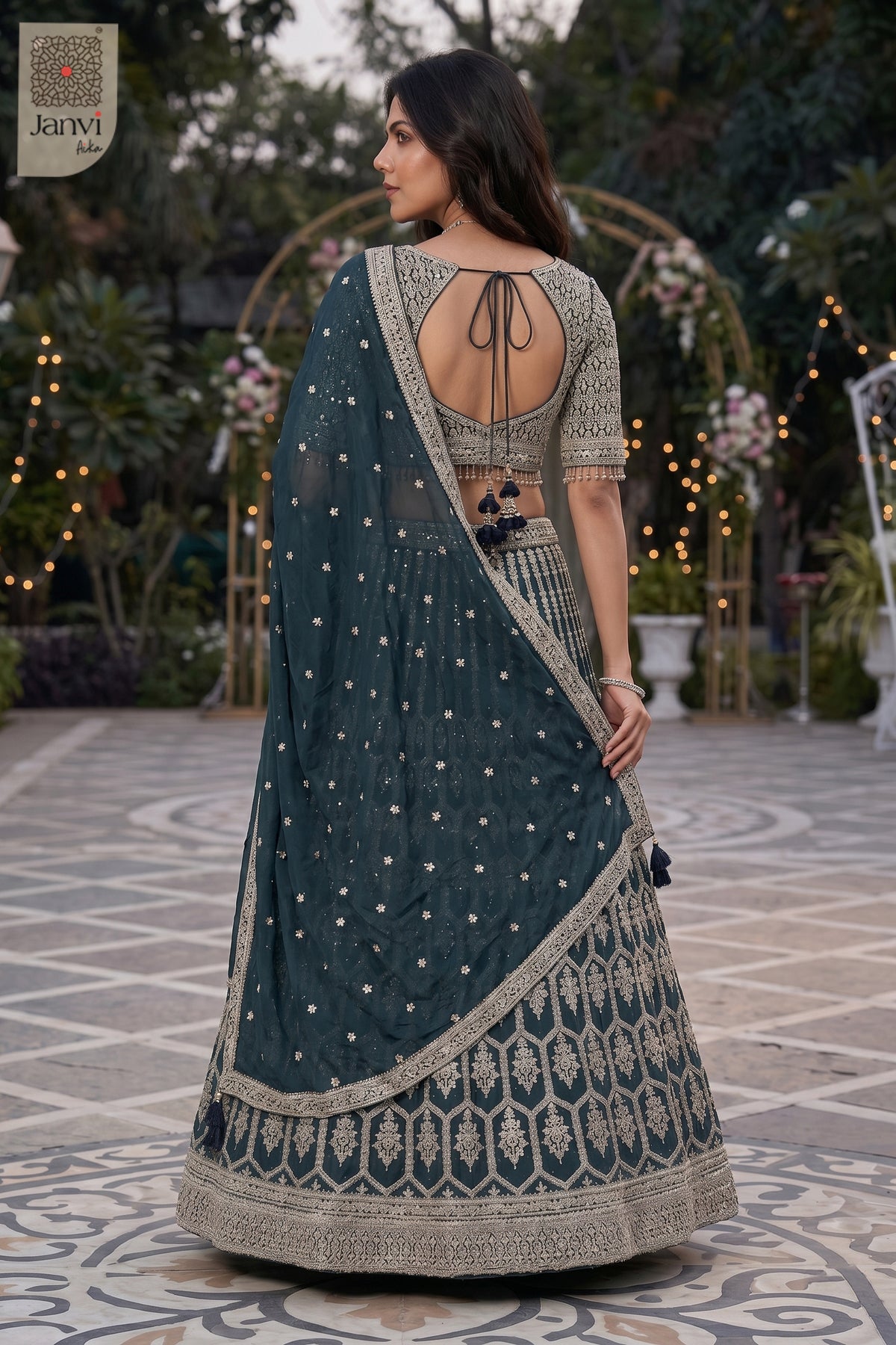 Rear full standing shot of a classic bottle green georgette lehenga choli with long blouse design.