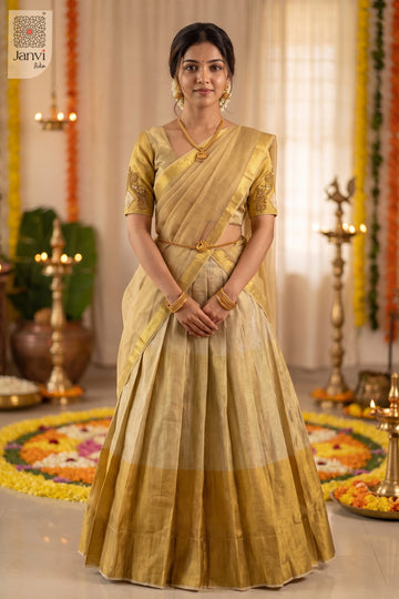 Full length standing pose of a monochrome gold wedding lehenga saree in festive decor.