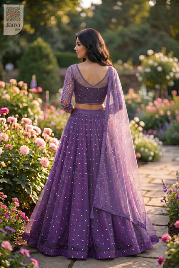 This rear full standing shot showcases a gorgeous purple net heavy bridal lehenga.