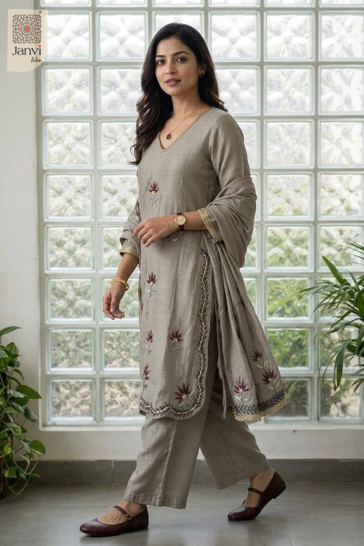 Mid length front standing pose with hands clasped in a grayish blue chudidar set.