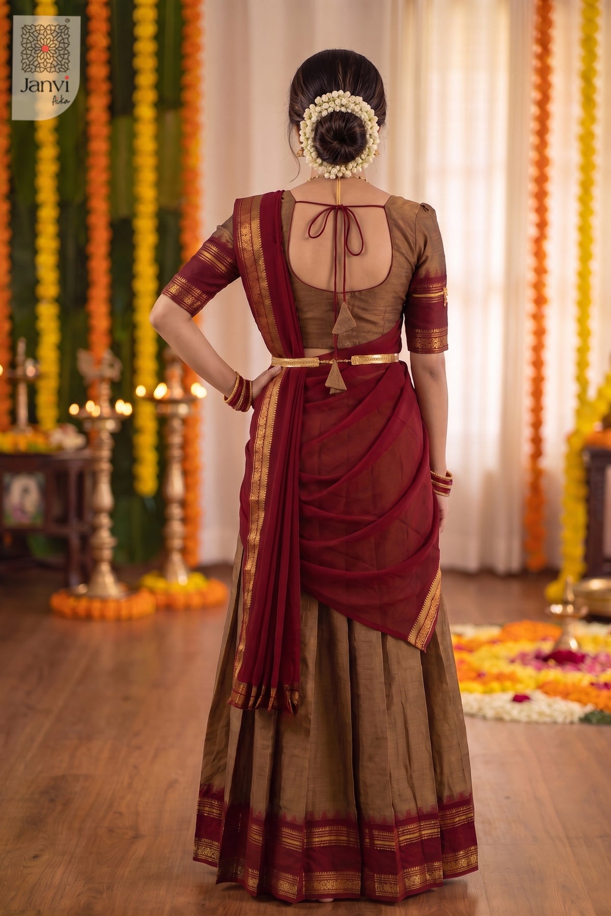 Rear view of tied doris on a bronze saree lehenga blouse with maroon pleated drape.