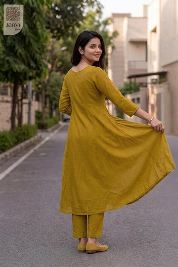 Rear view of a mustard yellow flared anarkali kurta with matching scalloped dupatta.