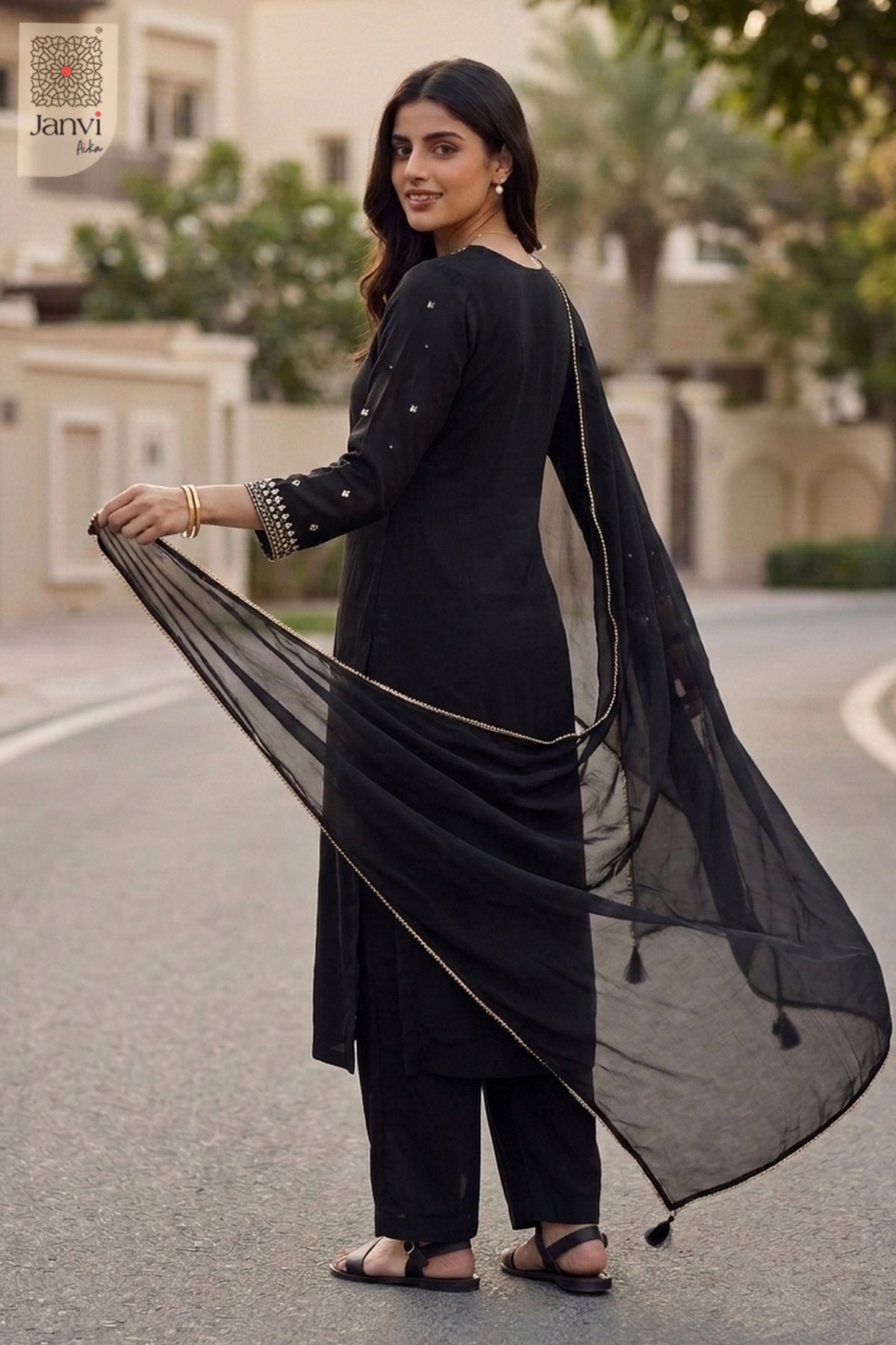 Rear view of an elegant black embroidered anarkali kurta with sheer dupatta drape.
