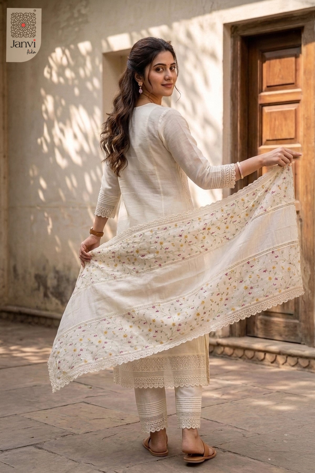 Rear view of a half white anarkali kurta with delicate floral lace edged dupatta.