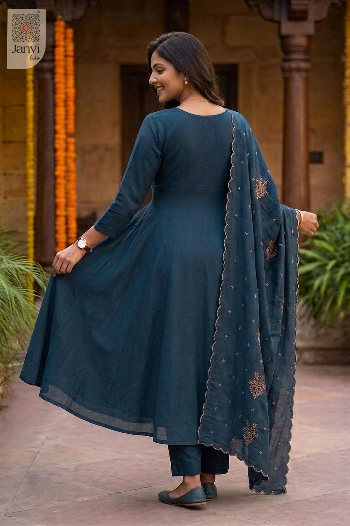 Rear view of a teal blue flared anarkali kurta with matching draped dupatta.